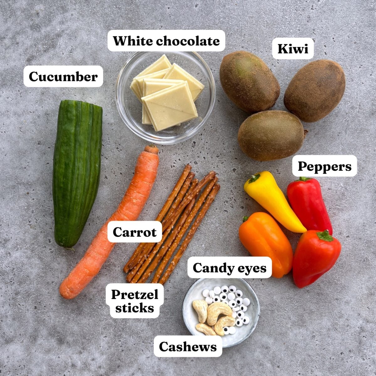 Cucumber, white chocolate, kiwi, carrot, pretzel sticks, peppers, candy eyes, and cashews.