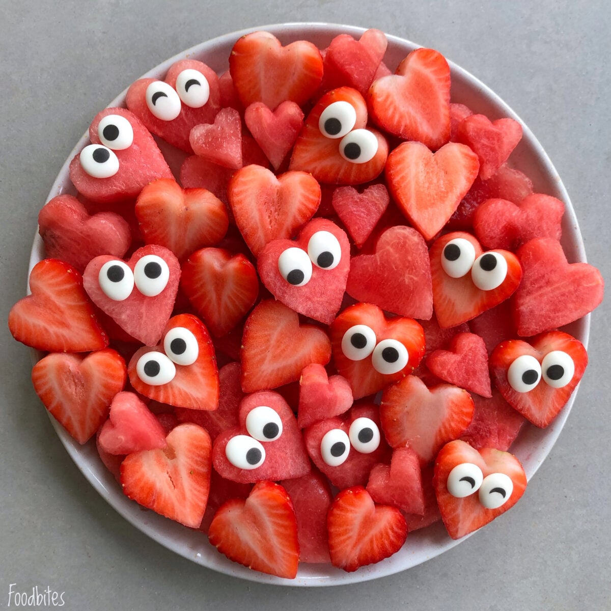 A Heart Shaped Fruit Platter features watermelon and strawberry slices cut into hearts, each topped with candy eyes.