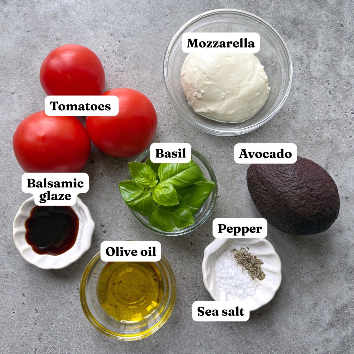 Tomatoes, fresh mozzarella, basil, a whole avocado, balsamic glaze, olive oil, salt, and pepper.