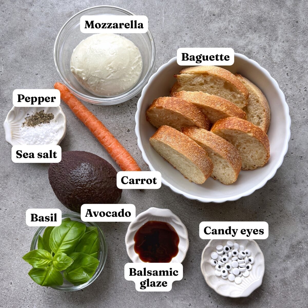 Mozzarella, baguette slices, pepper, sea salt, a carrot, an avocado, basil, balsamic glaze, and candy eyes.