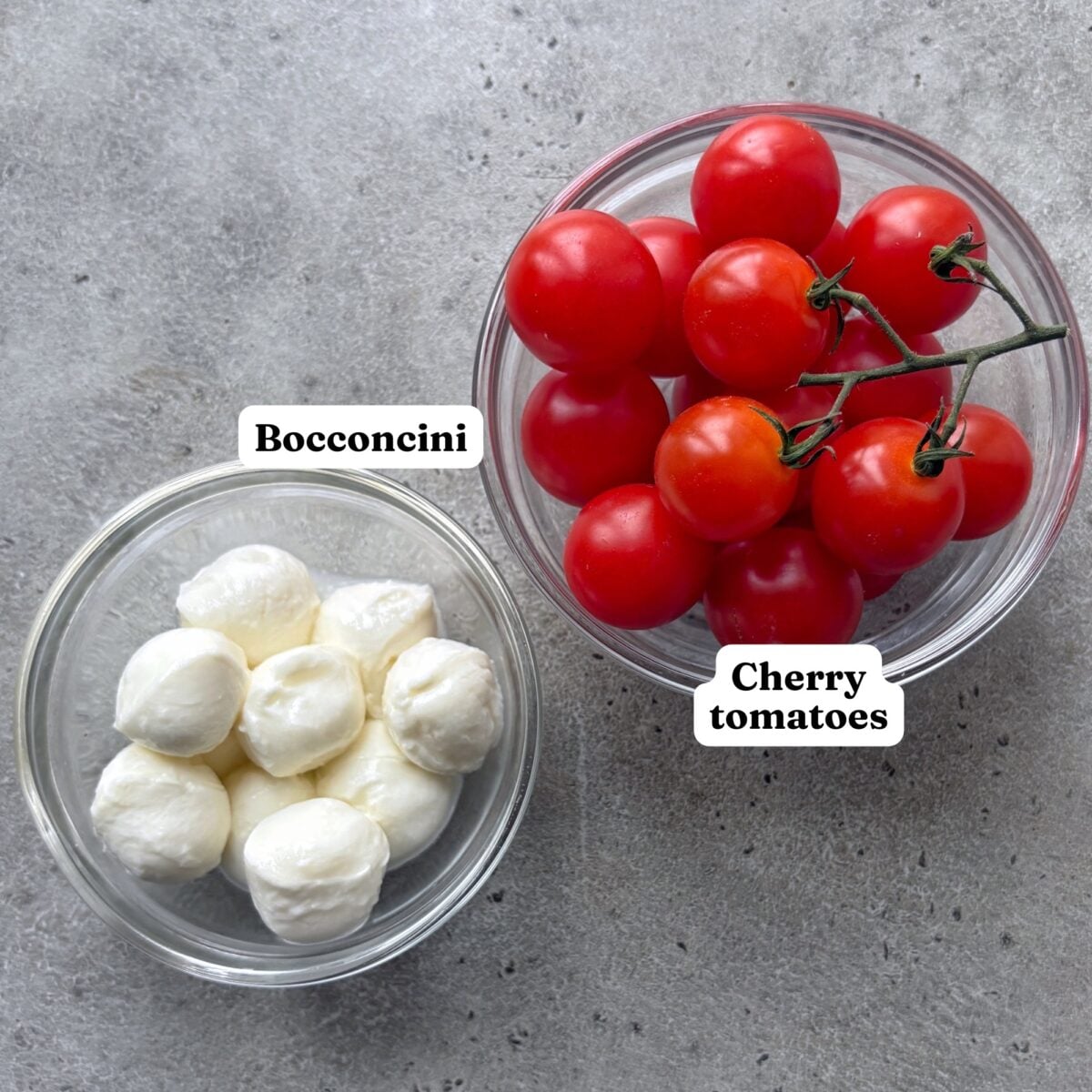 Glass bowls of bocconcini and cherry tomatoes.