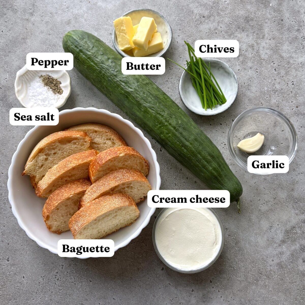 Baguette slices, cucumber, butter, chives, garlic, cream cheese, sea salt, and pepper.