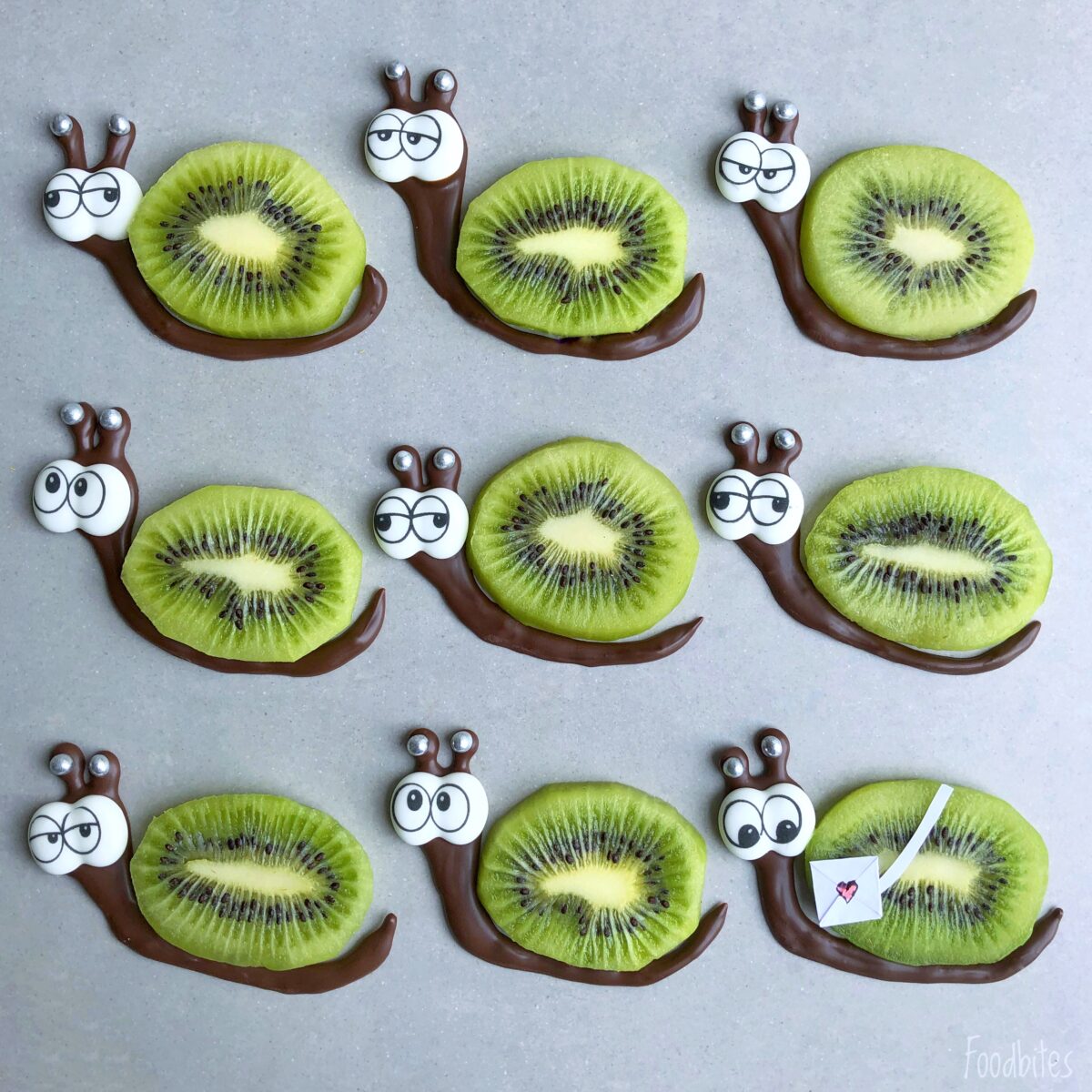 Nine adorable kiwi snails, crafted from kiwi slices for bodies with chocolate and candy eyes.
