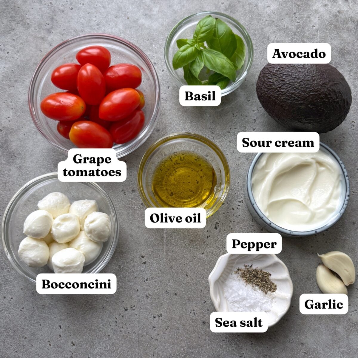 Grape tomatoes, basil, avocado, bocconcini, olive oil, sour cream, pepper, sea salt, and garlic cloves.