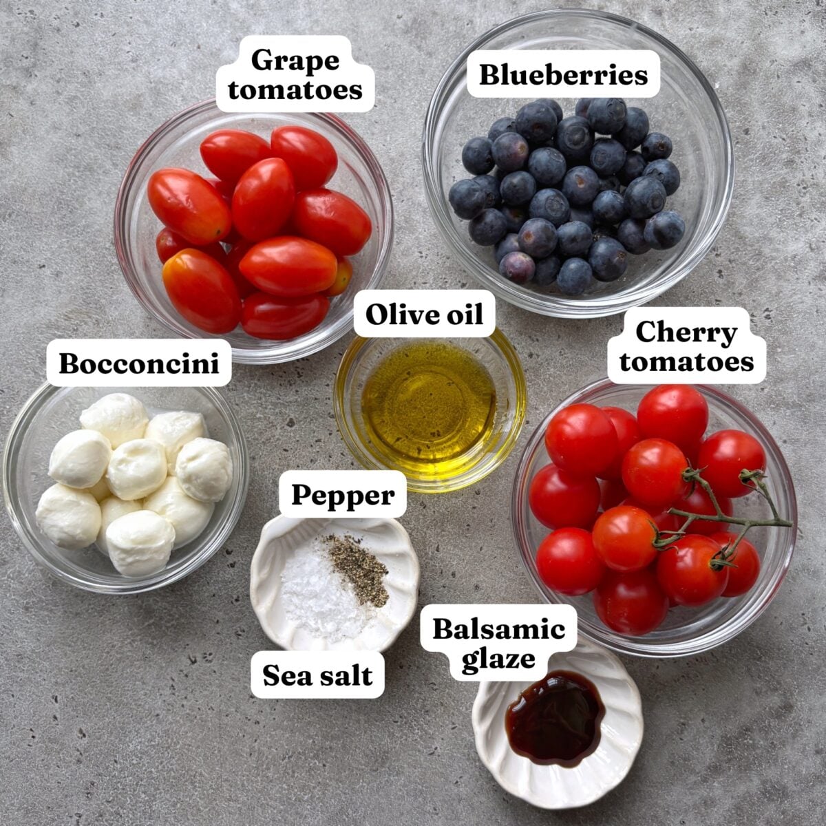 Grape tomatoes, blueberries, bocconcini, olive oil, salt, pepper, cherry tomatoes, and balsamic glaze.