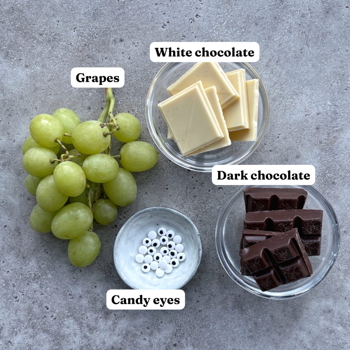 Green grapes, bowls of white and dark chocolate, and candy eyes.