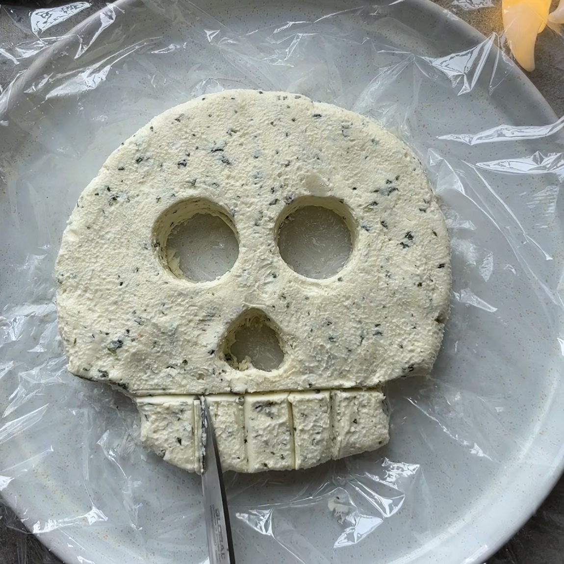 A knife trims skull teeth.