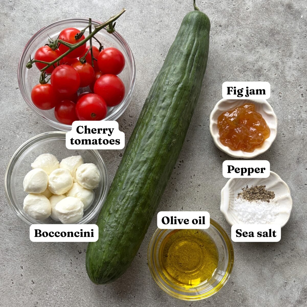 Cherry tomatoes, a cucumber, bocconcini, fig jam, olive oil, pepper, and sea salt.