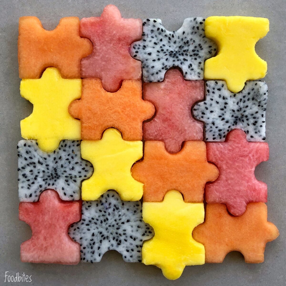 Puzzle fruit salad with mango, cantaloupe, dragonfruit, and watermelon.