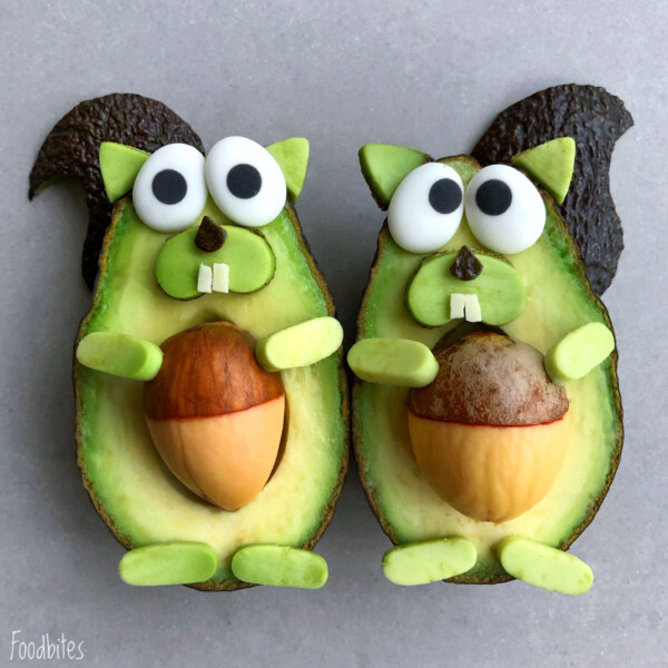 Two avocado halves decorated to look like squirrels, with dark peels as tails, nuts as bellies, and creative features for eyes, noses, teeth, arms, and feet from various foods—perfect for fun bites or inspiring healthy food recipes.