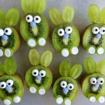 Kiwi slices decorated to look like bunnies using green grape halves for ears, candy eyes, blue candies for noses, and white candies for feet make adorable, healthy bites perfect for fun food recipes or creative dishes.