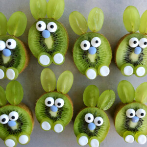 Kiwi slices decorated to look like bunnies using green grape halves for ears, candy eyes, blue candies for noses, and white candies for feet make adorable, healthy bites perfect for fun food recipes or creative dishes.