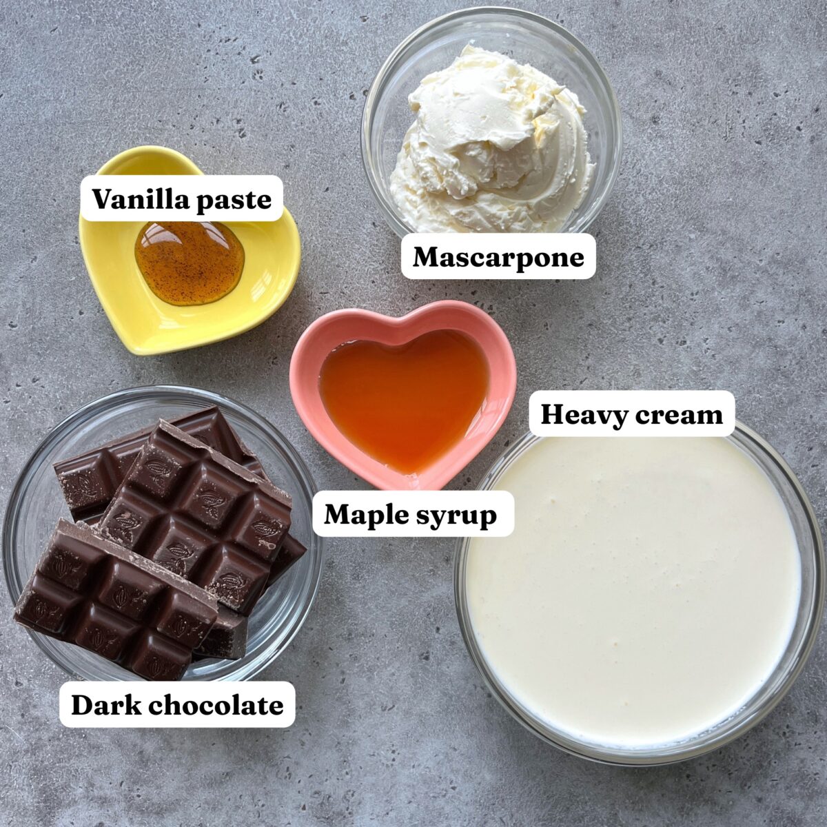 Five bowls containing the ingredients for Dark Chocolate Mousse including vanilla paste, mascarpone, dark chocolate, maple syrup, and heavy cream. Each ingredient is labeled.