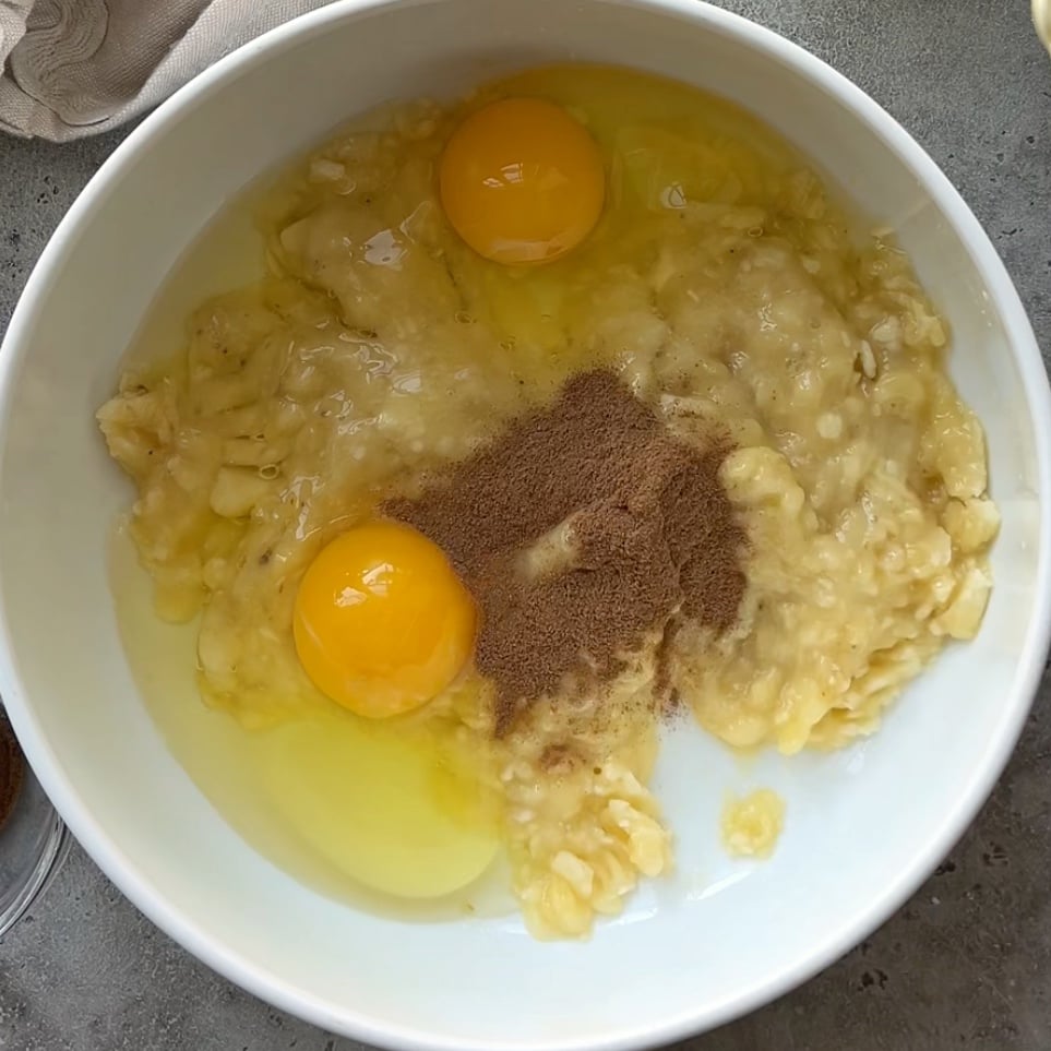 An unmixed banana waffle batter featuring eggs, cinnamon, and mashed banana. 