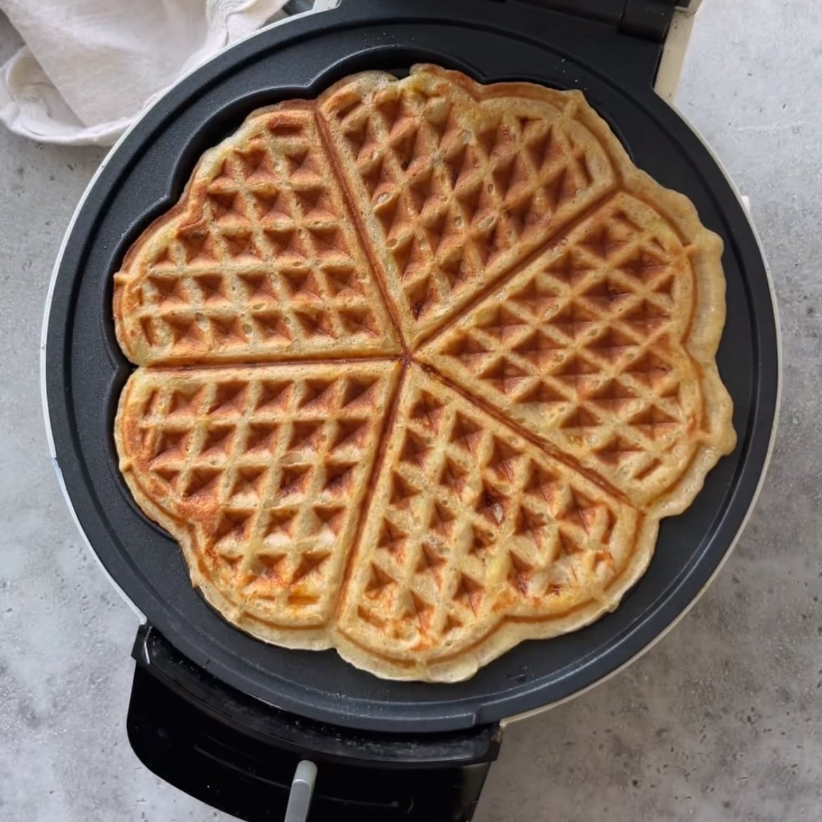 A freshly made banana waffle still in the iron.