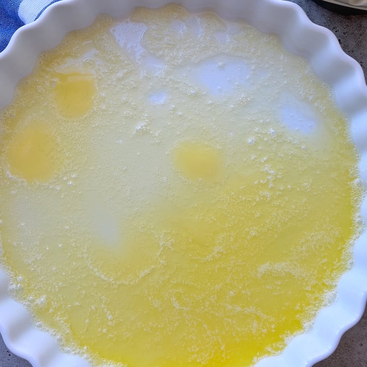 A white fluted dish filled with melted butter.