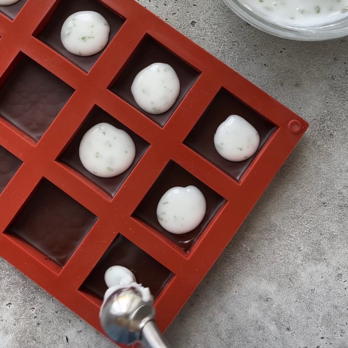 Red silicone mold being filled with a white, minty filling.