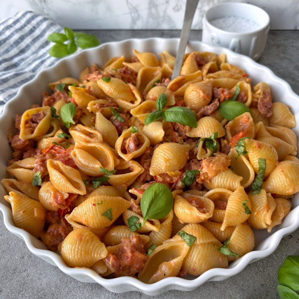 A side view of Spicy Italian Sausage Pasta topped with a spoon.