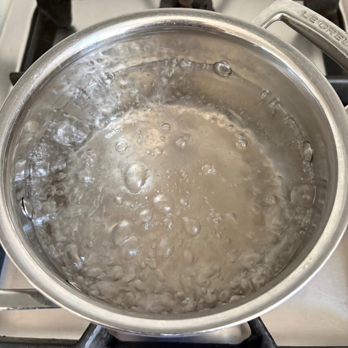 A saucepan with boiling water is ready to boil pasta.