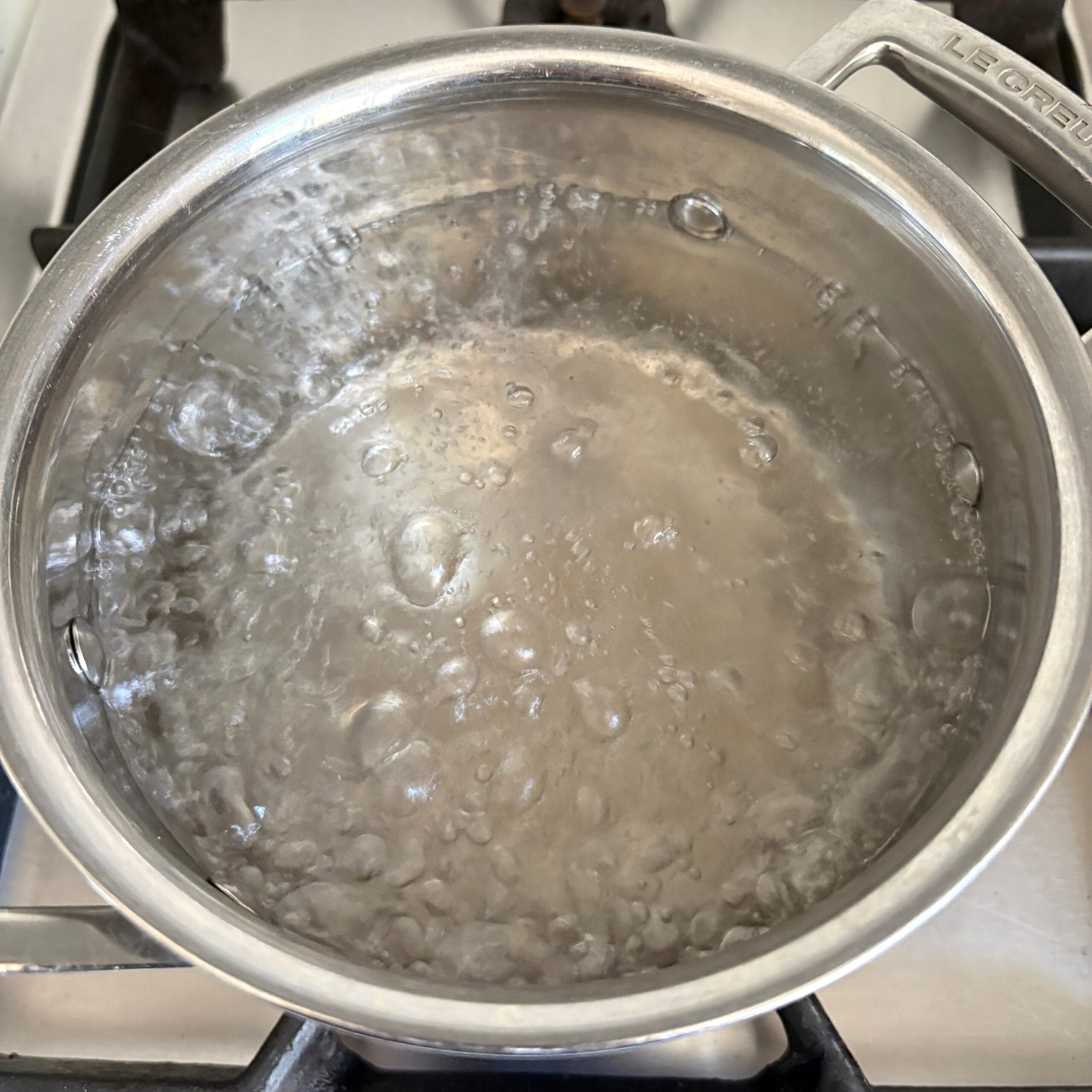 A saucepan with boiling water is ready to boil pasta.