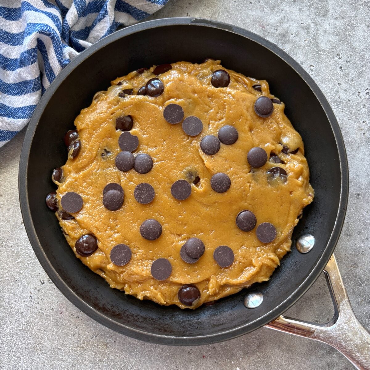 An unbaked pizookie in a small skillet is ready to be baked.