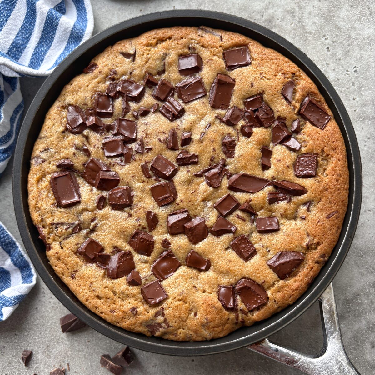 A baked and warm chocolate chip skillet cookie ready to be topped with ice cream.