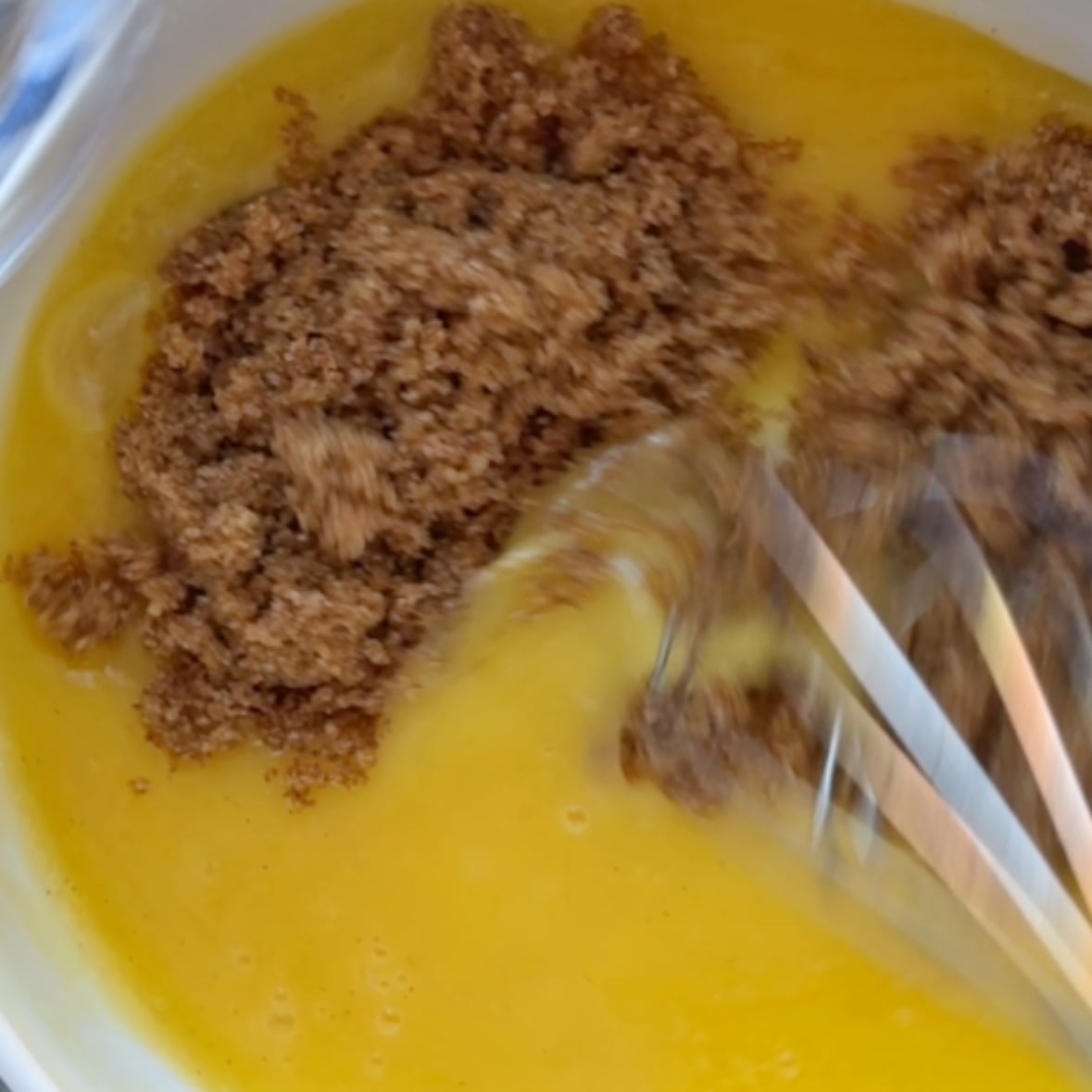 Melted butter, vanilla paste, and light brown sugar being mixed in a bowl.