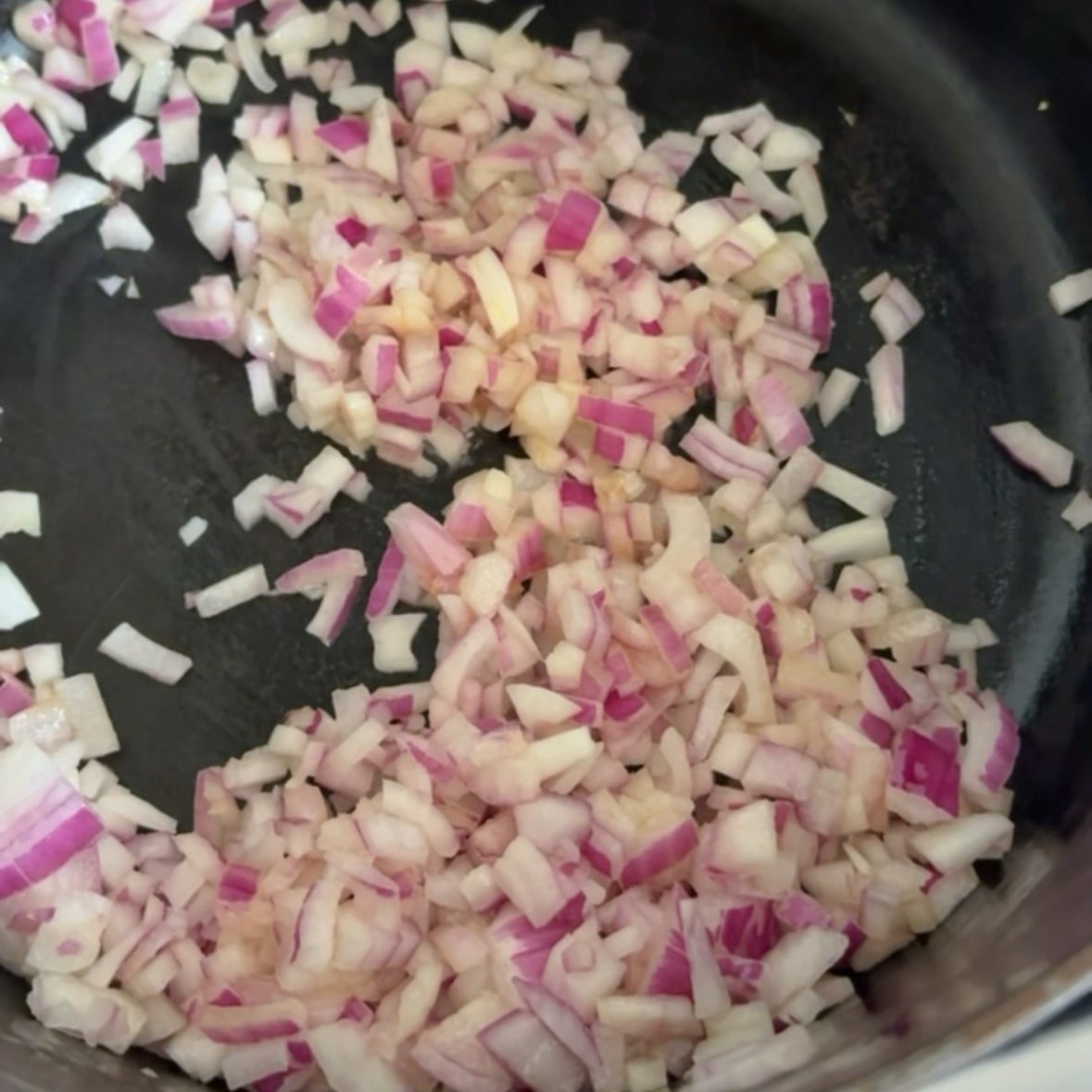 Chopped red onion sautéing in butter in a medium saucepan.